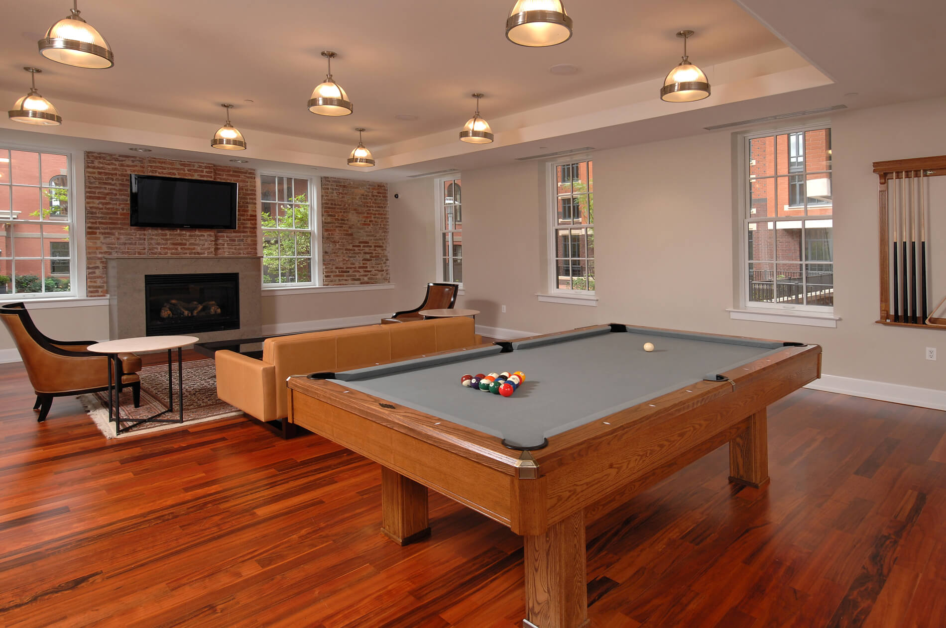 Pool table with seating, pendant lighting, fireplace and views of the outdoors