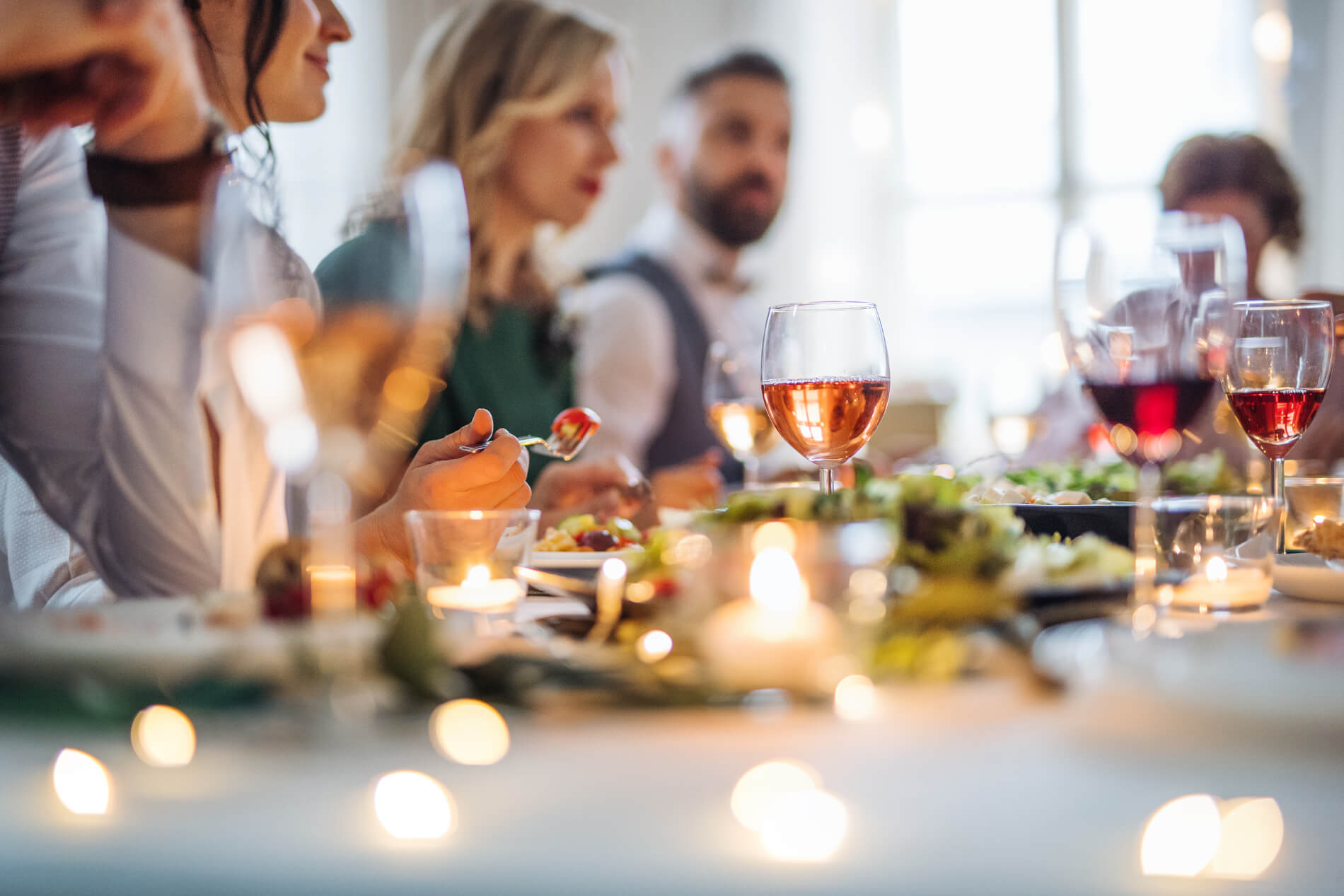 Several friends around festive table with food and wine